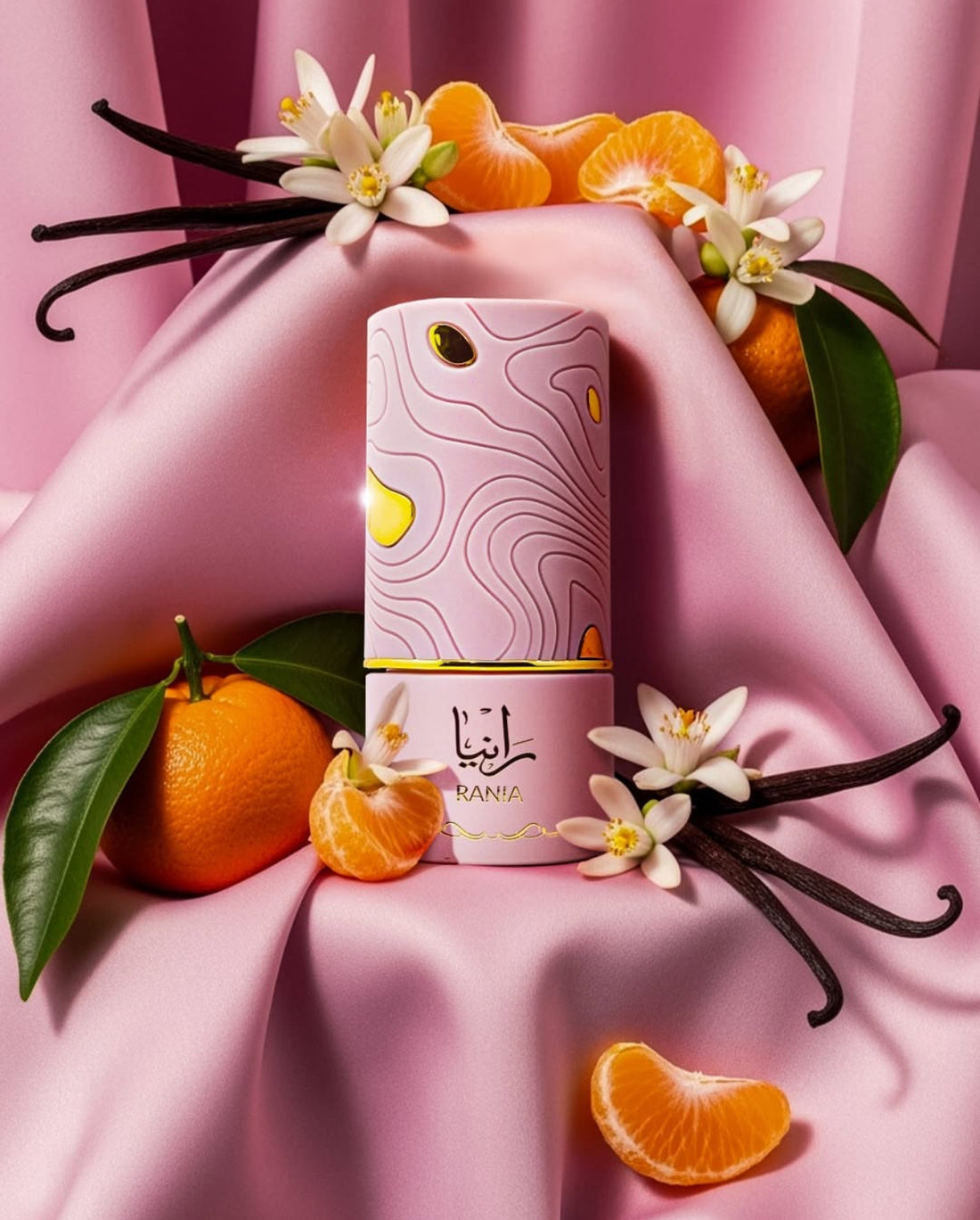 Rania - Al Absar EDP 100ml displayed with citrus fruits and flowers on pink satin fabric.