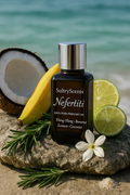 SultryScent Nefertiti perfume oil with Ylang-Ylang, Banana, Lemon, and Coconut beside coconut and lime on a stone.